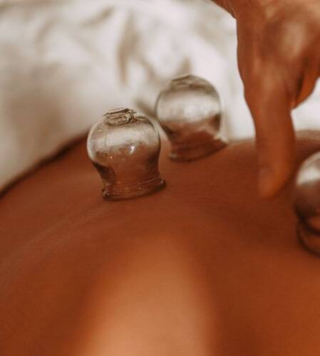 En persons rygg med tre koppar för koppningsterapi i glas och en hand som justerar en av kopparna. Perfekt för dig som utforskar alternativa behandlingar som akupunktur eller söker expertis hos en kiropraktor Göteborgsspecialist. En persons rygg med tre koppar för koppningsterapi i glas och en hand som justerar en av kopparna. Perfekt för dig som utforskar alternativa behandlingar som akupunktur eller söker expertis hos en kiropraktor Göteborgsspecialist.